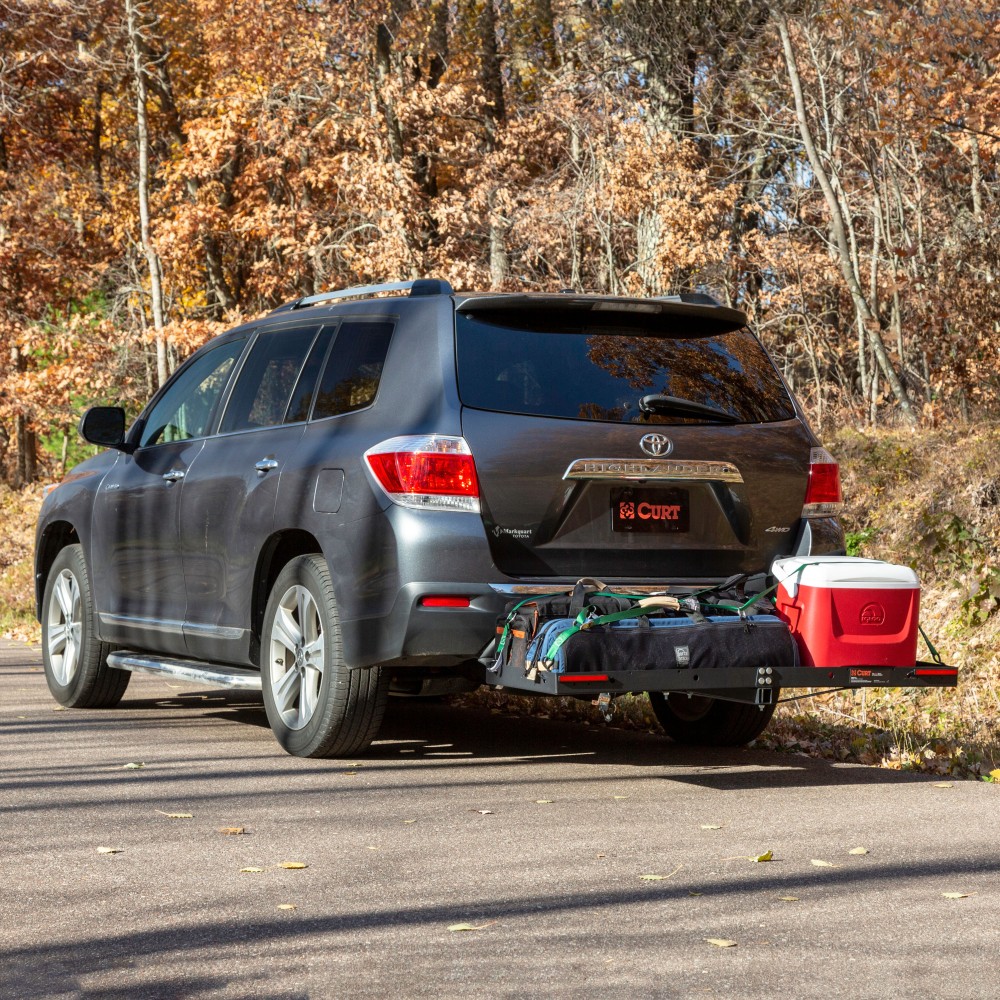 CURT trailer hitch cargo carrier, mesh tray-style, black powder coat, mounted on vehicle.