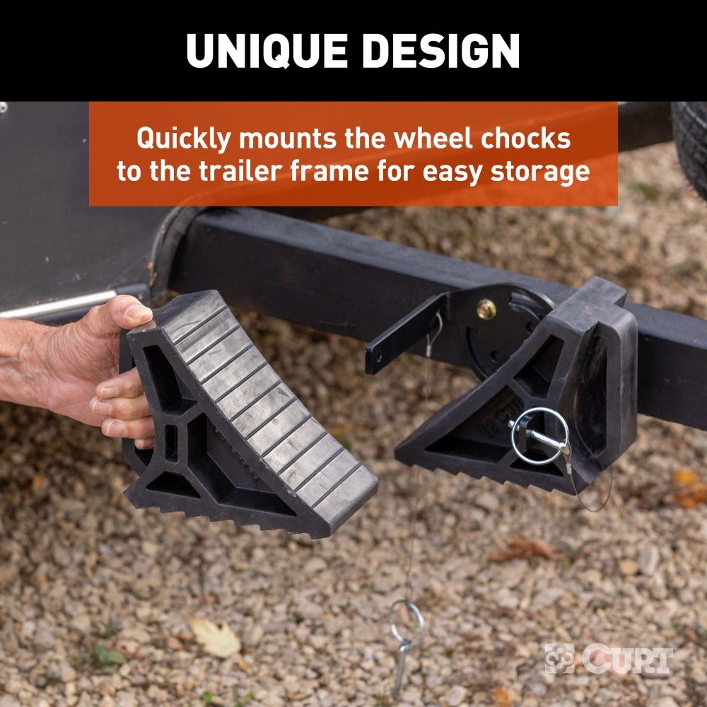 CURT HD Wheel Chocks with Mounting Bracket for Trailers CURT HD wheel chocks mounted on trailer frame with orange finish