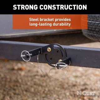 CURT HD Wheel Chocks with Mounting Bracket for Trailers CURT HD wheel chocks mounted on trailer frame with orange finish