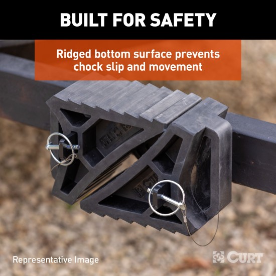 CURT HD Wheel Chocks with Mounting Bracket for Easy Storage CURT HD wheel chocks with mounting bracket attached to trailer, shown in use.