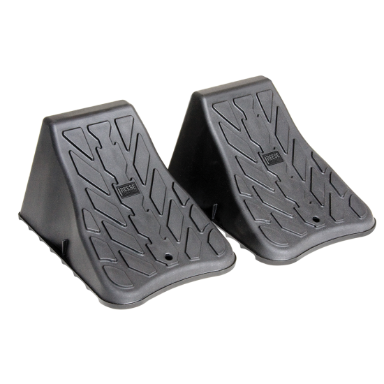 High Impact Polymer Trailer Wheel Chocks for Stability A pair of high impact polymer wheel chocks placed under trailer tires.