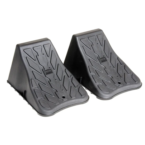 High Impact Polymer Trailer Wheel Chocks for Stability A pair of high impact polymer wheel chocks placed under trailer tires.